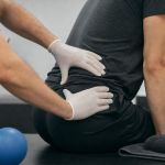 Massage nerf sciatique : mains en kinésithérapie sur hanche et fesse